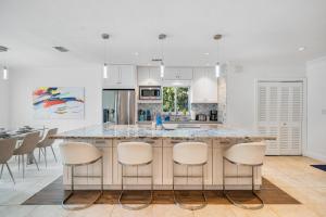 a kitchen with a large island with bar stools at Exclusive Miami House: Your Private Pool Paradise in Biscayne Park