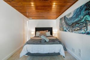 a bedroom with a bed with a painting on the wall at Exclusive Miami House: Your Private Pool Paradise in Biscayne Park