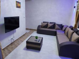 a living room with a couch and a tv at RS VILLAS SHARE APARTMENT with private room ,good wifi, 150mts to beaches bus stop.and , in Flic-en-Flac
