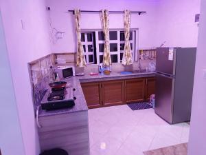a kitchen with a stove and a refrigerator at RS VILLAS SHARE APARTMENT with private room ,good wifi, 150mts to beaches bus stop.and , in Flic-en-Flac