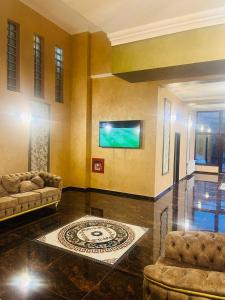 a living room with two couches and a flat screen tv at Hotel La Ane in Babadau