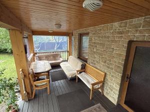 a porch with a couch and a table and chairs at Holiday home Imanta in Riga