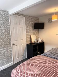 a bedroom with a bed and a door with a television at Bramley House in Boston