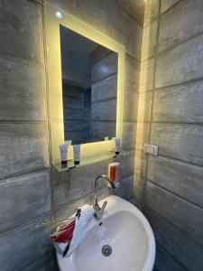 een badkamer met een wastafel en een spiegel bij Locanda Pyramids Hotel in Caïro