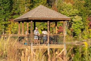 two people sitting in a gazebo on the water at Juneberry Ridge in Norwood