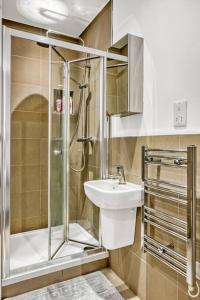 W łazience znajduje się prysznic i umywalka. w obiekcie Heathrow 2-Bedroom Urban Oasis w Londynie