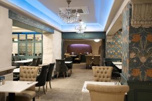 a dining room with tables and chairs and a chandelier at Bushtown Hotel & Spa in Coleraine