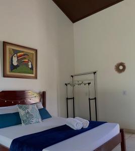 a bedroom with two beds and a picture on the wall at Suites Vossoroca in Alto Paraíso de Goiás