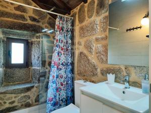 a bathroom with a toilet and a sink and a shower at Aldeia de Pontes - Castro Laboreiro in Castro Laboreiro +85 photos