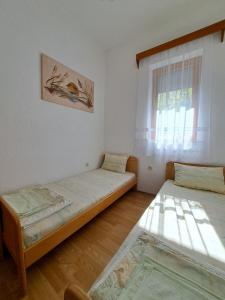 2 camas en una habitación con ventana en Gjorgji Apartments 68a, en Ohrid