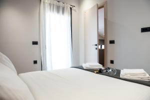 - un lit blanc dans une chambre avec un miroir dans l'établissement Lovely Guesthouse - 58m2 mountain view, à Ioannina