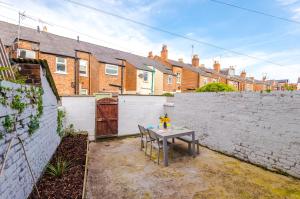 a backyard with a table and a brick wall at Central 2-bed home in Chester by 53 Degrees Property - Amazing location, Ideal for Couples - Sleeps 4! in Chester