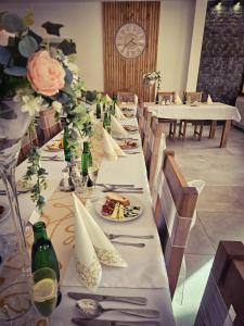 una mesa larga con platos de comida y flores en Hotel Krpáčovo en Krpacovo