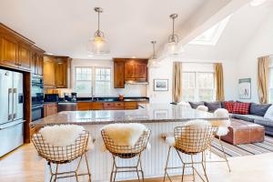 a kitchen with a bar with chairs and a couch at Meadow View Retreat in Stowe