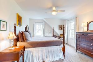 a bedroom with a bed and a dresser and two windows at Meadow View Retreat in Stowe