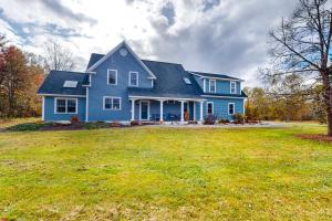 a blue house with a large yard at Meadow View Retreat in Stowe