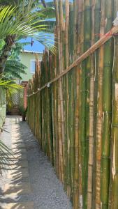 une clôture avec des bâtons de bambou dans une cour dans l'établissement Lavínia loft 5, à Búzios