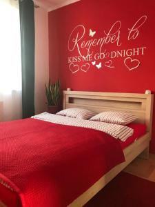 a bedroom with a bed with a red wall at Apartament Jantarowa in Gdynia