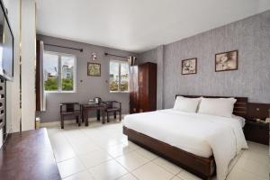 a bedroom with a bed and a table and windows at Sen Sai Gon Hotel - Ben Thanh Market in Ho Chi Minh City