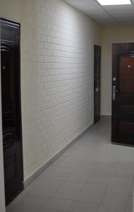 a hallway with two doors and a white brick wall at 4 Komnaty in Yaroslavl