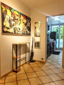 una habitación con pinturas en la pared y un pasillo en La Casa Picasso, en Villepinte