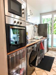 una cucina con piano cottura e forno a microonde di La Casa Picasso a Villepinte