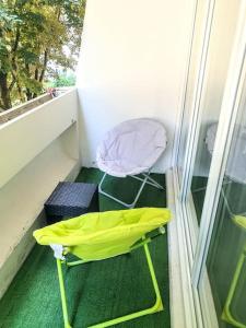 a yellow umbrella and a chair on a balcony at La Casa Picasso in Villepinte