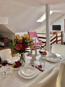 a white table with a vase of flowers on it at Casuta cu amintiri in Cîmpulung