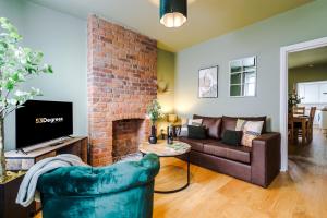 a living room with a couch and a brick fireplace at NEW! Gorgeous 2-bed home in Chester City Centre by 53 Degrees Property - Incredible location, Ideal for Small Groups - Sleeps 6! in Chester