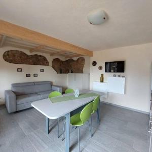 un soggiorno con divano, tavolo e sedie di Istanti - Rosmarino a Costigliole Saluzzo