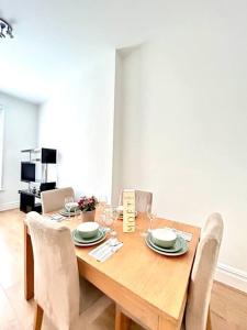 een houten tafel met stoelen en een eetkamer bij Maida Vale Serenity: 2-Bedroom in Londen