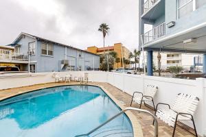 a swimming pool with chairs next to a building at Skyline 406 in St. Pete Beach