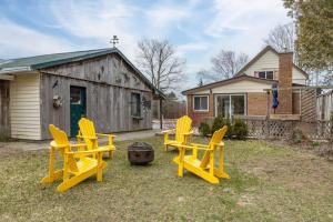 a group of yellow chairs sitting in a yard at West Lake Nook: Near Sandbanks Park in West Lake
