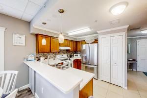 a kitchen with white countertops and wooden cabinets at Skyline 406 in St. Pete Beach