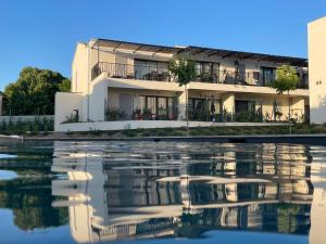 an apartment building with its reflection in the water at Les Papillons du Ventoux - Le Myrtil- éénslaapkamerappartement met terras en tuin in Malaucène