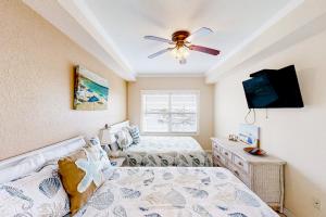 a bedroom with two beds and a ceiling fan at Skyline 406 in St. Pete Beach