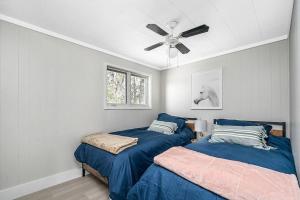 a bedroom with two beds and a ceiling fan at West Lake Nook: Near Sandbanks Park in West Lake