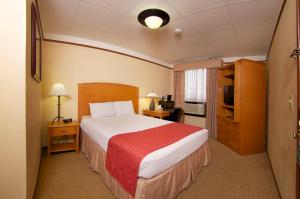 a hotel room with a bed with a red blanket at Historic Plains Hotel in Cheyenne