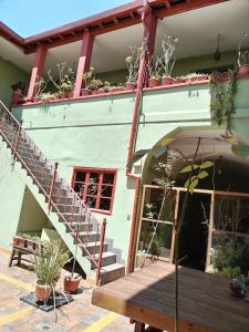 a building with a staircase and a wooden table at ALSIGAL COCHABAMBA Casa de Huéspedes in Cochabamba