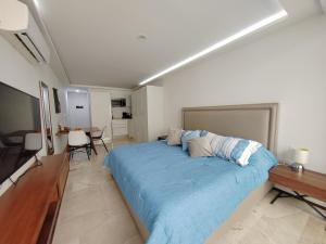 a bedroom with a large bed and a desk at NEW! Encantador estudio a unos pasos de la Playa By Yeah in Playa del Carmen
