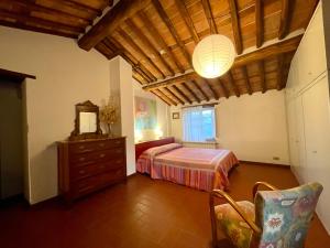 um quarto com uma cama, uma cómoda e um candeeiro em La casa In Valli 35 em Bagni di Lucca