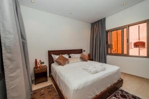 sypialnia z łóżkiem z białą pościelą i oknem w obiekcie Dar Nourdha w Marakeszu