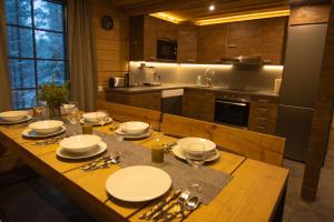 a kitchen with a wooden table with plates and silverware at Tunturipöllö 3 in Ruka