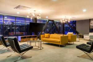 a living room with a yellow couch and chairs at Downtown Designer Apartments by ULIV in Tijuana