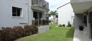 a building with a balcony and a grass yard at INNIKOL 55 in Mossel Bay