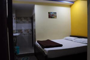 a small bedroom with a bed and a sink at G.M Luxury Hotel in Srīsailam