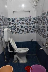 a bathroom with a toilet with a floral wallpaper at G.M Luxury Hotel in Srīsailam