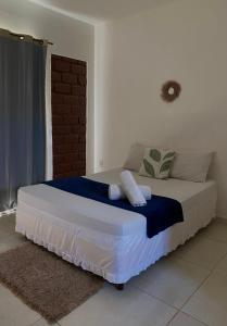 a bedroom with a bed with a blue and white blanket at Suites Vossoroca in Alto Paraíso de Goiás