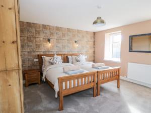 a bedroom with a large bed and a table at Hardhills Cottage in Castle Douglas