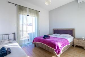 - une chambre avec un lit et une couverture violette dans l'établissement Delight apartment LA, à Larissa